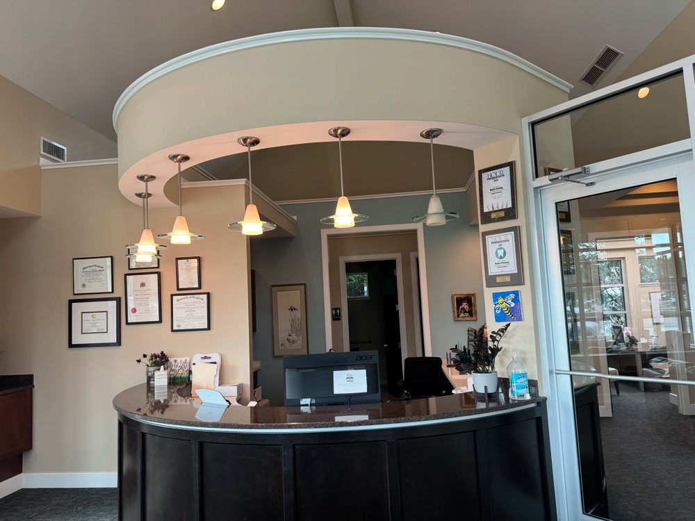 The front desk at Lakes Pediatric Dentistry, with pendant lights and framed diplomas